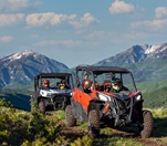 A group pf people riding off-road in UTVs